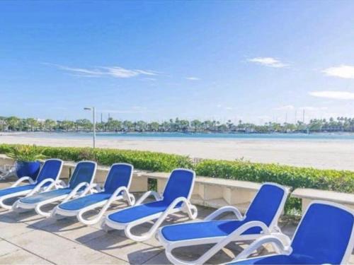 a row of blue chairs sitting in front of a beach at Apartment Carabela Chic by Interhome in Alcudia