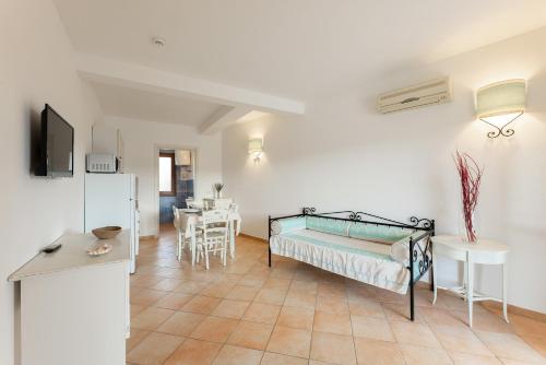a living room with a bed and a table at Baia dei Mirti 4 people Apartment in Vignola Mare