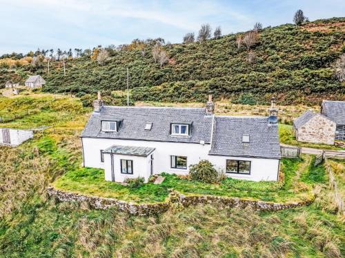 Holiday Home Bunloit Farmhouse by Interhome في Inverfarigaig: اطلالة جوية على بيت ابيض على تلة