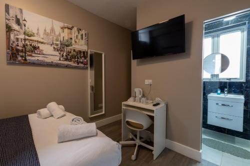 a room with a bed and a desk and a mirror at Paragraph Tottenham in Southgate