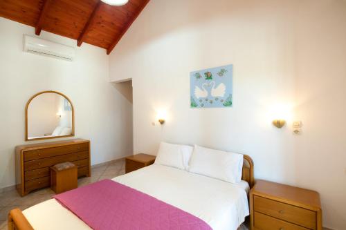 a bedroom with a bed and a dresser and a mirror at Krista House in Agios Gordios