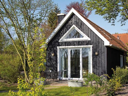 een zwart huis met een raam aan de zijkant bij Ferienhaus Clara in Klein Scharrel