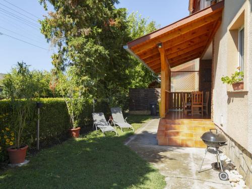 a patio with two chairs and a grill in a yard at Apartment Pajtas 2 by Interhome in Balatonfenyves