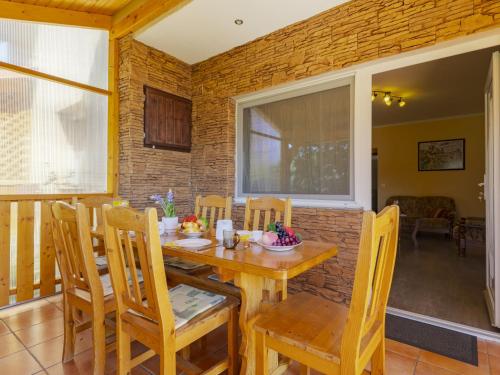 a dining room with a wooden table and chairs at Apartment Pajtas 2 by Interhome in Balatonfenyves