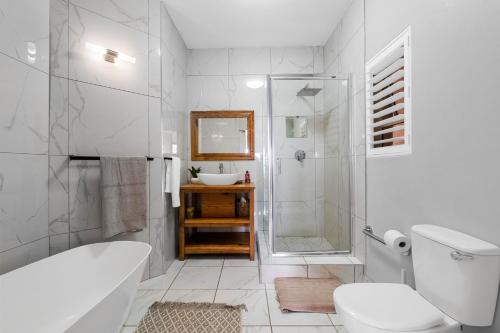 a bathroom with a toilet and a shower and a sink at 10 Gleneagles, Salt Rock in Ballito