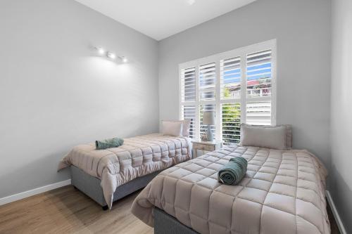 a bedroom with two beds and a window at 10 Gleneagles, Salt Rock in Ballito