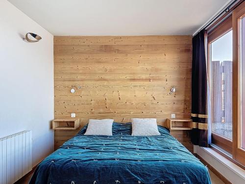 - une chambre avec un lit et un mur en bois dans l'établissement Apartment La Nova-2 by Interhome, à Arc 1800