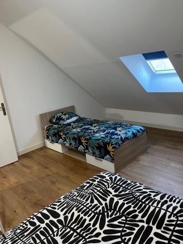 a attic bedroom with two beds and a window at Appartement F2 de 55 m2 in Blanzy