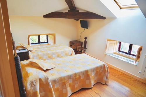 a bedroom with two beds and two windows at Casa Los Lomas in Arenas de Iguña