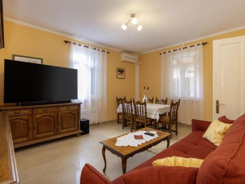a living room with a couch and a tv and a table at Holiday Home Adele by Interhome in Labin