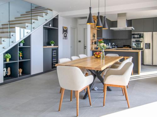 a kitchen and dining room with a wooden table and white chairs at Villa Marmonte by Interhome in Lovran