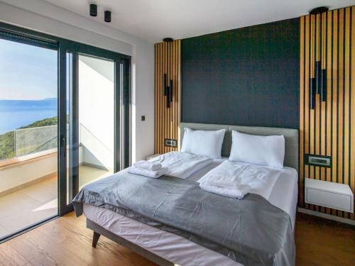 a bedroom with a large bed and a large window at Villa Marmonte by Interhome in Lovran