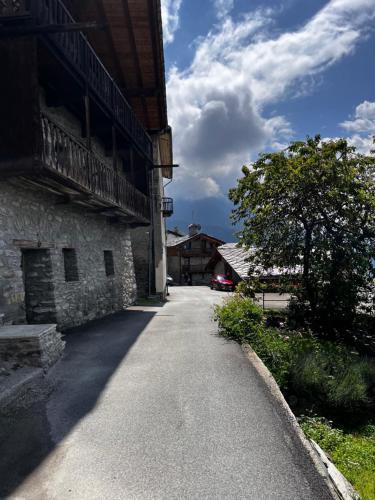 an empty road next to a building with a tree at Chalet Cheverel (AO) in Remondey