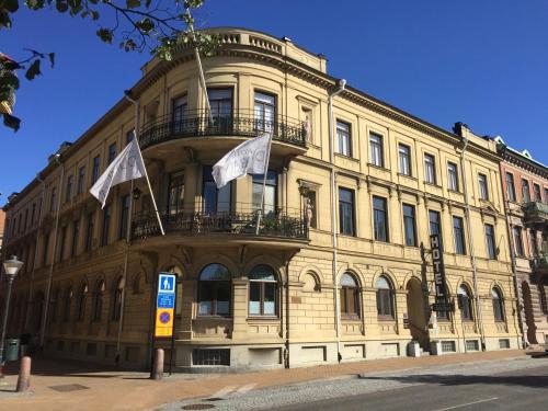 un bâtiment avec deux drapeaux devant lui dans l'établissement Hotel Park Allé, à Kristianstad