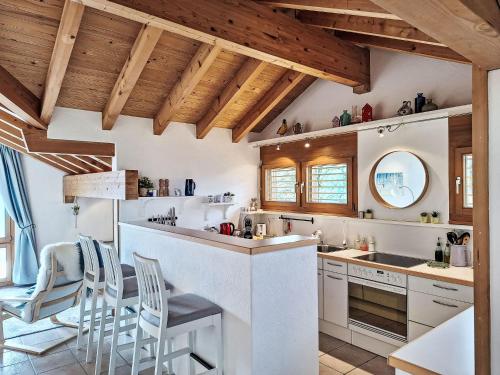 a kitchen with white counters and wooden ceilings at Apartment Möösli Vue by Interhome in Sundlauenen