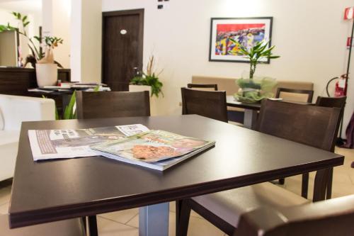 a table with a newspaper and a magazine on it at Hotel Fontanelle in Fratta Terme