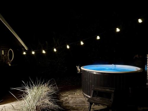 Holiday Home Yvette - 350m from the sea by Interhome في Hejlsminde: حوض جاكوزي في فناء مظلم مضاء