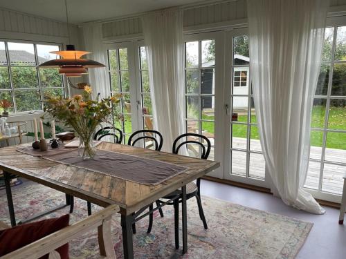 Holiday Home Yvette - 350m from the sea by Interhome في Hejlsminde: غرفة طعام بها طاولة وكراسي ونوافذ