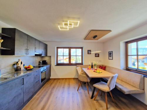 a kitchen and dining room with a table and a couch at Apartment Almluft by Interhome in Weerberg