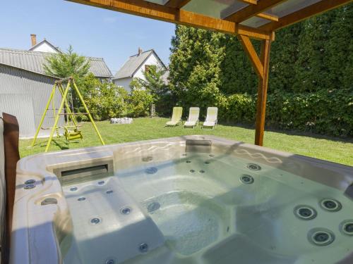 Holiday Home Wild Grape by Interhome في بالاتونماريافوردو: حوض استحمام ساخن في الفناء الخلفي مع أرجوحة