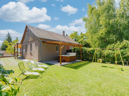 Holiday Home Wild Grape by Interhome في بالاتونماريافوردو: حديقة خلفية مع أرجوحة ومنزل