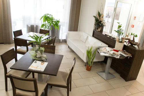 a living room with a couch and a table and chairs at Hotel Fontanelle in Fratta Terme