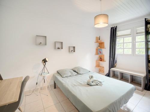 a bedroom with a bed with a stuffed animal on it at Villa Zenitude Caraïbes in Les Trois-Îlets