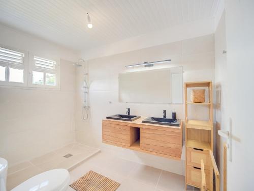 a bathroom with two sinks and a mirror at Villa Zenitude Caraïbes in Les Trois-Îlets