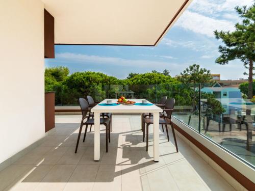 een witte tafel en stoelen op het balkon van een huis bij Apartment Iris Suite-3 by Interhome in Bibione