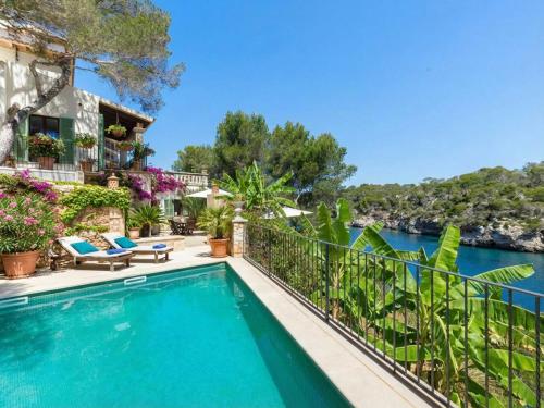 een huis met een zwembad met uitzicht op het water bij Villa Cala Figuera in Santanyi