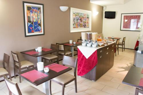 a restaurant with tables and chairs and a counter at Hotel Fontanelle in Fratta Terme