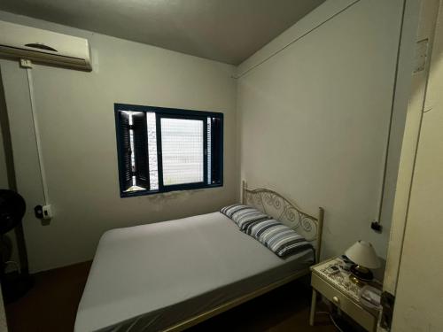 a small bedroom with a bed and a window at Pousada Papirella in São Gabriel