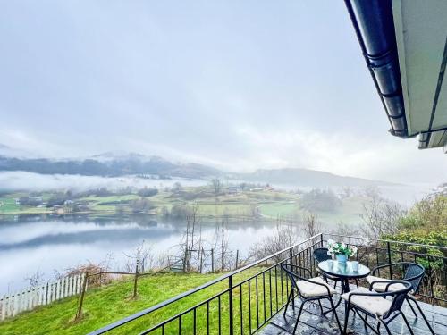 a balcony with a table and chairs and a view of a lake at Apartment Samlen Vasselgård by Interhome in Herand