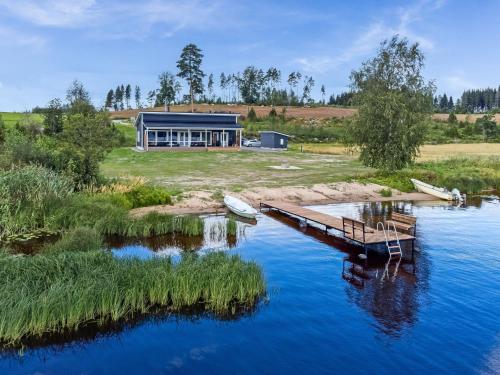 una casa sulla riva di un fiume con un molo di Holiday Home Tervaleppä by Interhome a Sipsiö