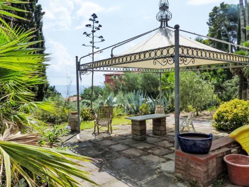 a pergola with a bench in a garden at Apartment Villa Le Palme by Interhome in Rio Marina