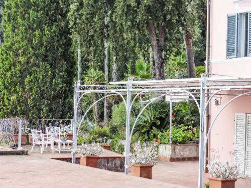 an outdoor patio with a pergola and tables and chairs at Apartment Villa Le Palme by Interhome in Rio Marina