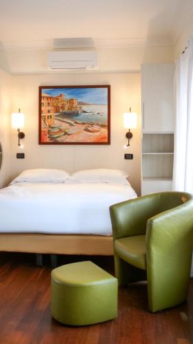 a hotel room with a bed and a chair at Rex Hotel Residence in Genoa