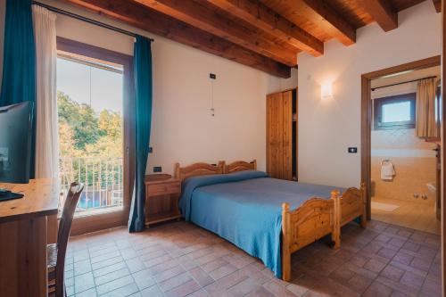 a bedroom with a bed and a large window at Agriturismo P rato Fiorito in Santi Angeli