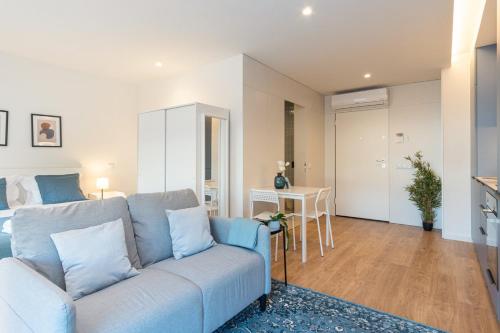 a living room with a blue couch and a bedroom at GuestReady - A peaceful city refuge in Porto