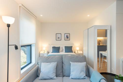ein Schlafzimmer mit einem Bett und einem Sofa mit Kissen in der Unterkunft GuestReady - A peaceful city refuge in Porto