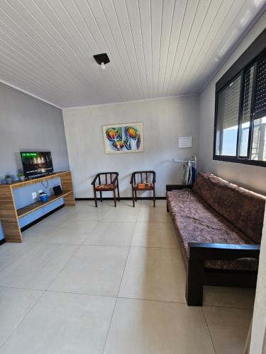 a living room with a couch and two chairs at Casa 264 in Capão da Canoa