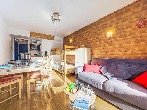 a living room with a couch and a table and a kitchen at Apartment Soyouz Vanguard-106 by Interhome in Le Corbier