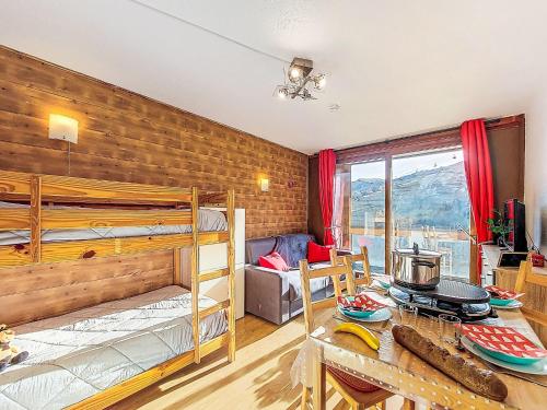 a bedroom with bunk beds and a dining room with a table at Apartment Soyouz Vanguard-106 by Interhome in Le Corbier