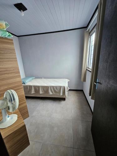 a small room with a bed and a window at Casa 264 in Capão da Canoa