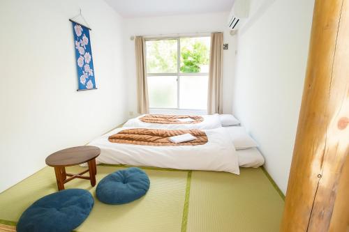 - une chambre avec un lit et deux ottomanes bleues dans l'établissement Sakura Hotel Nippori, à Tokyo