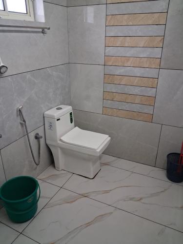 une salle de bain avec toilettes et un seau vert dans l'établissement Jerusalem Home Saty, à Idukki