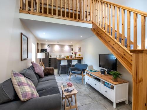 Una sala de estar con un sofá y una escalera. en Holiday Home Wayside Bothy by Interhome, en Drumnadrochit