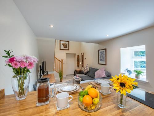 una sala de estar con una mesa con frutas y flores en Holiday Home Wayside Bothy by Interhome, en Drumnadrochit