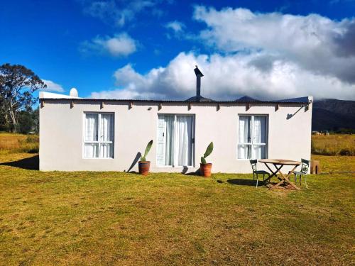 a white house with a cross on top of it at Cornelia's Field in Joubertina