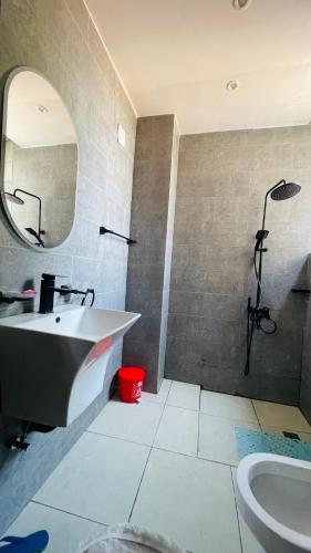 a bathroom with a sink and a mirror at AGASARO LUXURY Apartment in Kigali
